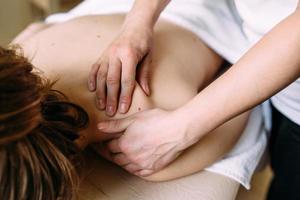 masajista haciendo masajes en el cuerpo femenino en el spa. el concepto de procedimientos cosméticos. foto