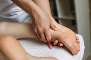 el masajista da un masaje a los pies femeninos en el spa. el concepto de procedimientos cosméticos.