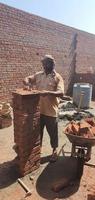 Sialkot, Pakistan, June 2022, A mason is joining brick with cement to create a wall. photo