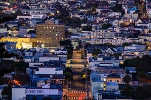 vista de la colina del vecindario de la hora dorada de las casas de san francisco, techos puntiagudos, coloridos y pintorescos con algunas casas victorianas, una vista típica de san francisco. foto