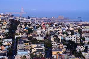 vista de la colina del vecindario de la hora dorada de las casas de san francisco, techos puntiagudos, coloridos y pintorescos con algunas casas victorianas, una vista típica de san francisco. foto