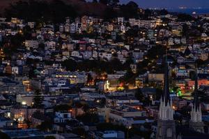 vista de la colina del vecindario de la hora dorada de las casas de san francisco, techos puntiagudos, coloridos y pintorescos con algunas casas victorianas, una vista típica de san francisco. foto