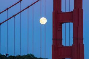 Majestic San Francisco Golden Gate Bridge with June 2022 full moon rising and the north tower as seen from Marin Headlands in California photo