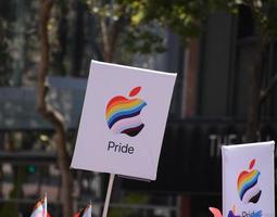 San Francisco, CA, USA - June 22, 2022, Pride Parade, Apple Corporation Contingent member carrying Apple Pride logo sign photo