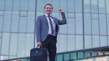 Young successful businessman, luxury building. Young businessman in a suit is standing in front of a luxury building. video