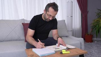 Office worker working at home. The employee, who continues his work at home, examines a file and takes notes. video