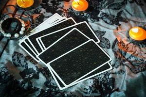 Tarot reading with tarot card background and candlelight on the table for Astrology Occult Magic Spiritual Horoscopes and Palm reading fortune teller tarot reader photo