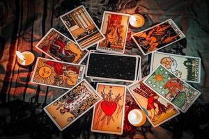 Tarot reading with tarot card background and candlelight on the table for Astrology Occult Magic Spiritual Horoscopes and Palm reading fortune teller tarot reader photo