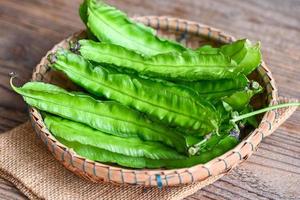 Winged Bean on basket and sack background, Psophocarpus tetragonolobus - Green winged or Four angle beans photo