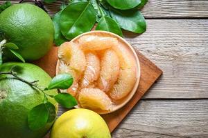 pomelo fruit on wooden plate  background, fresh green pomelo peeled and leaf frome pomelo tree , pummelo , grapefruit in summer tropical fruit  in thailand photo