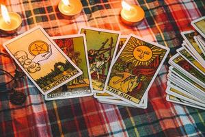 Tarot reading with tarot card background and candlelight on the table for Astrology Occult Magic Spiritual Horoscopes and Palm reading fortune teller tarot reader photo