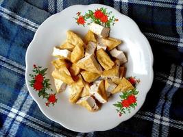 tahu goreng o tofu frito en un plato. comida culinaria indonesia foto