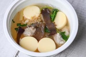 Menu healthy food egg tofu soup , clear soup bowl with pork jelly mushroom black jelly fungus vegetable and celery , vermicelli soup photo