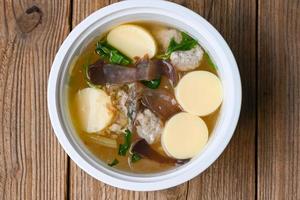 Menu healthy food egg tofu soup , clear soup bowl with pork jelly mushroom black jelly fungus vegetable and celery , vermicelli soup photo