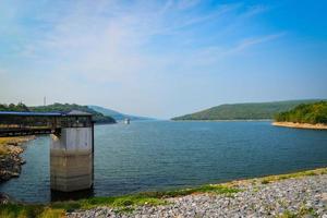 Water level meter Landscape with dam lake mountain reservoir with tower Water level meter on bright day photo