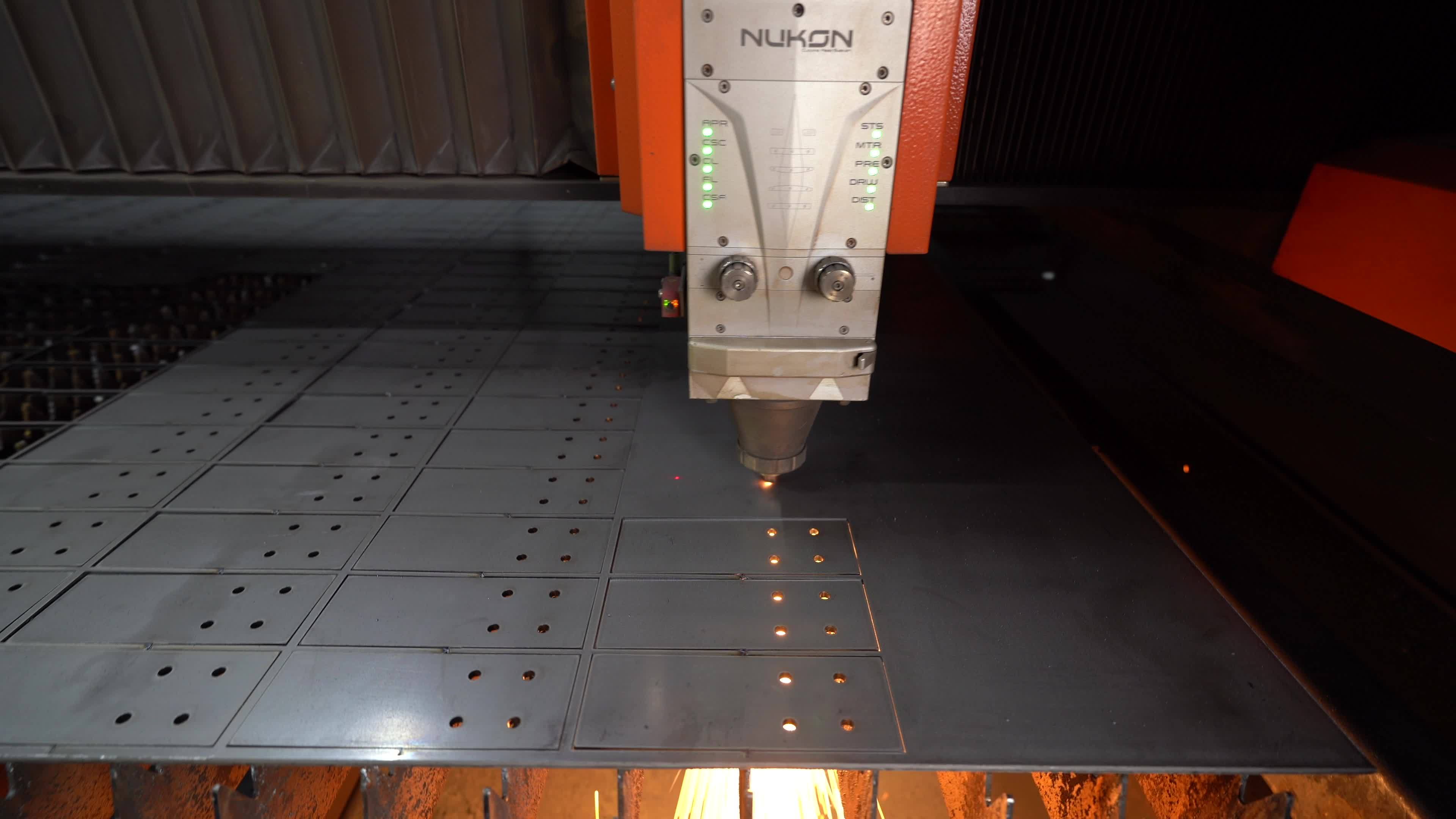 Industrial CNC laser cutting machine. A metal sheet is being cut on a