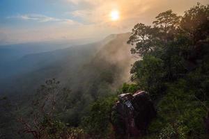 maravilloso paisaje amanecer montaña con niebla niebla cielo amarillo y azul sol naciente en la mañana foto