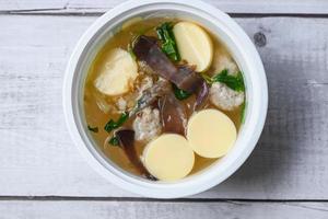 Menu healthy food egg tofu soup , clear soup bowl with pork jelly mushroom black jelly fungus vegetable and celery , vermicelli soup photo