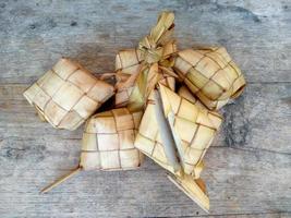 Ketupat or Rice Dumpling On Wooden Background. Indonesian culinary food photo