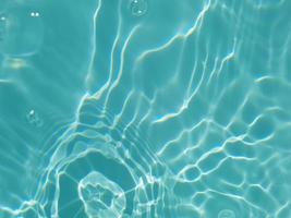 Defocus blurred water in swimming pool rippled water detail background photo