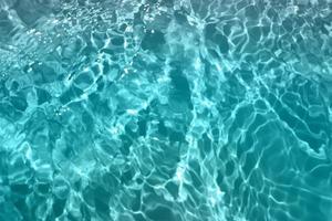 Defocus blurred blue watercolor in swimming pool rippled water detail background. Water splash, water spray background. photo