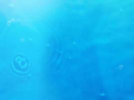 desenfoque de la acuarela azul borrosa en el fondo del detalle del agua ondulada de la piscina. salpicaduras de agua, fondo de pulverización de agua. foto