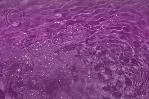 Defocus blurred purple watercolor in swimming pool rippled water detail background. Water splash, water spray background. photo