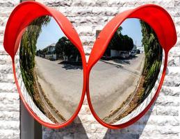 Traffic mirror on the wall at intersection or curve of road, safety and security concept, close up photo