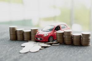 coche rojo sobre muchas monedas apiladas foto