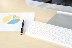 Office desk with monitors keyboards and the different graphs on paper. photo