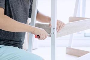 Young Asian Man Assembling shelves photo