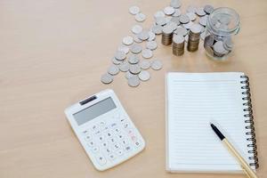 Office Note Book, Calculator, Coins and Pen photo