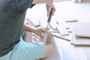 Man assembling furniture in his new home photo