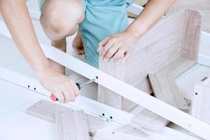 Young Asian Man Assembling shelves photo