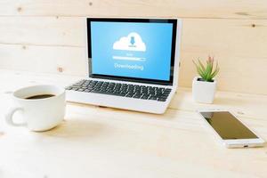 Cloud downloading on laptop  on wood table photo