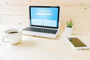 Online job search engine on laptop  on wood table photo