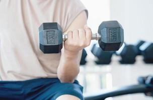 Man doing concentration curls exercise working out with dumbbell photo