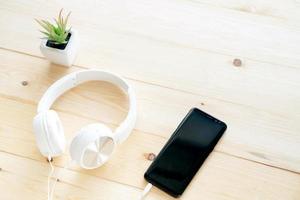 Smartphone and headphones on the table wood photo