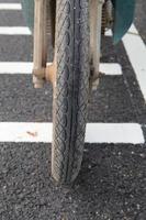 Close-up motorcycle wheels saw the wheels and tires on the reconstructed road - there was a warning xylophone ahead of the intersection and red light intersection. photo