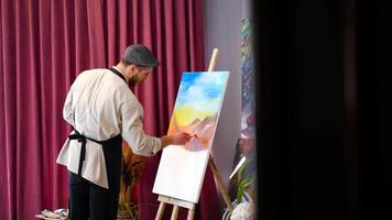 The painter is preparing an oil painting. General view of the painter working in an artistic space. video
