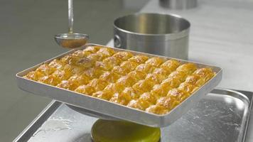 Making traditional Turkish dessert Baklava. The chef pours syrup on the baklava. video