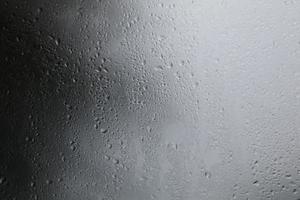 Raindrops on a black background Water droplets on a dark background Rain protection glass for cars that fall in the evenings that storm enter. photo