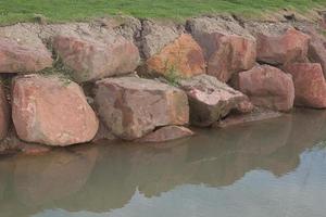 Brown stone with large patterns that are designed to be like nature by heavy machinery, beautifully crafted in a vast lakeside garden, perfect for relaxing and watching nature in summer and winter. photo