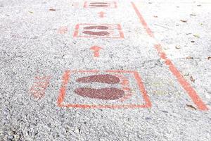 Foot symbols on the ground tell people to keep people 6 feet apart during the coronavirus outbreak in many countries around the world and common filtering points. photo