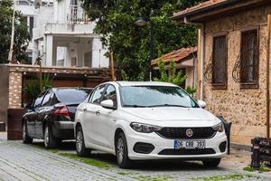 lado turquía 20 de febrero de 2022 blanco fiat egea está estacionando en la calle en un día de verano contra el telón de fondo de un hotel, parque foto