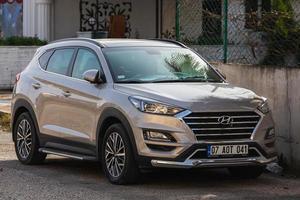 Side  Turkey  February 18 2022  silver Hyundai Tucson  is parked  on the street on a warm day against the backdrop of a fence photo