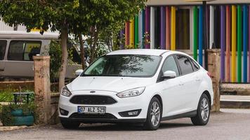 Turquía lateral 03 de marzo de 2022 Ford Focus blanco está estacionado en la calle en un día cálido con el telón de fondo de un parque, tienda foto