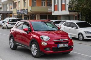 Side Turkey February  20, 2022 red Fiat 500  parked on the street on a warm summer day against the backdrop of  city traffic photo