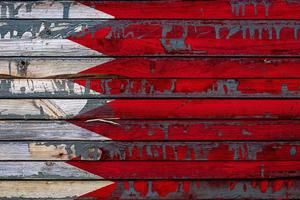 The national flag of Bahrain is painted on uneven boards. Country symbol. photo