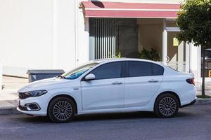 Side Turkey  February 20 2022  white   Volkswagen Polo is parked  on the street on a warm day against the backdrop of  shops photo